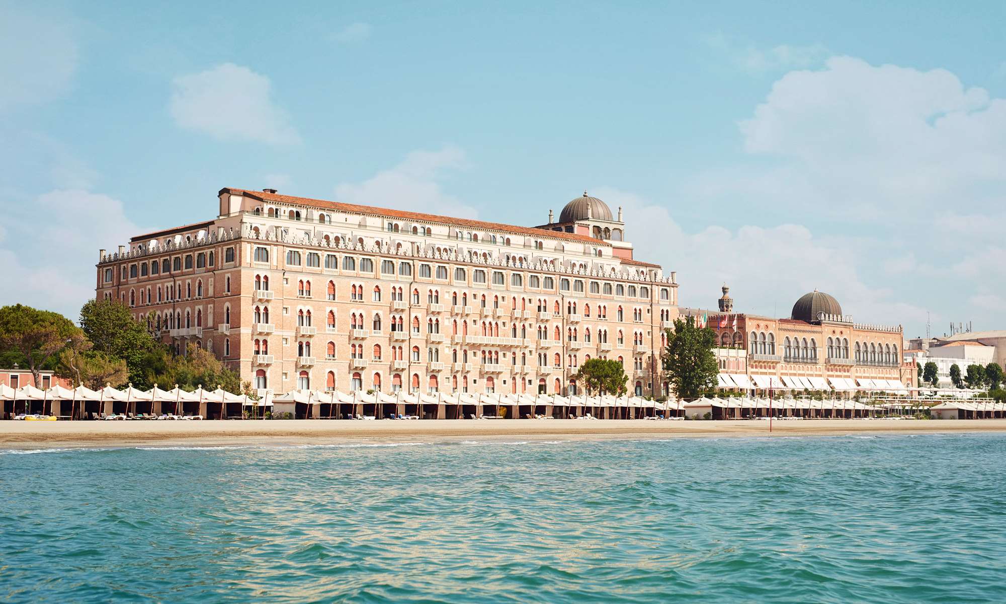 5 star hotel Venice Italy – Hotel Excelsior Venice Lido Resort facade glowing at sunset with Adriatic Sea view, best hotel in Italy Venice
