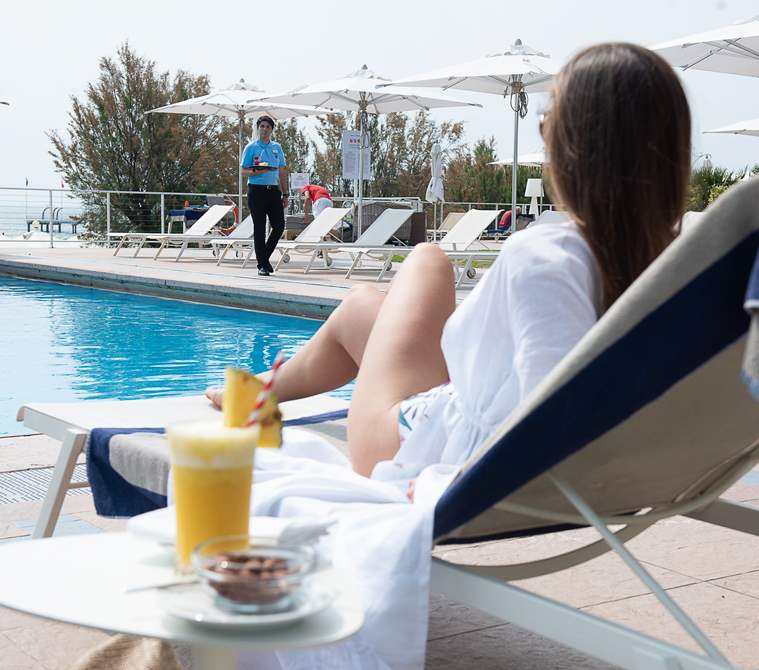 A guest relaxing by the pool | Hotel Excelsior Venice Lido Resort, beach resort in Venice, Italy