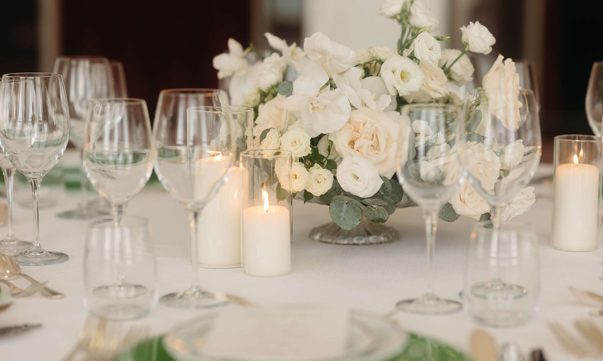 Elegant table setup for a romantic wedding in Venice Italy at Hotel Excelsior Venice Lido Resort, featuring soft candlelight and white roses