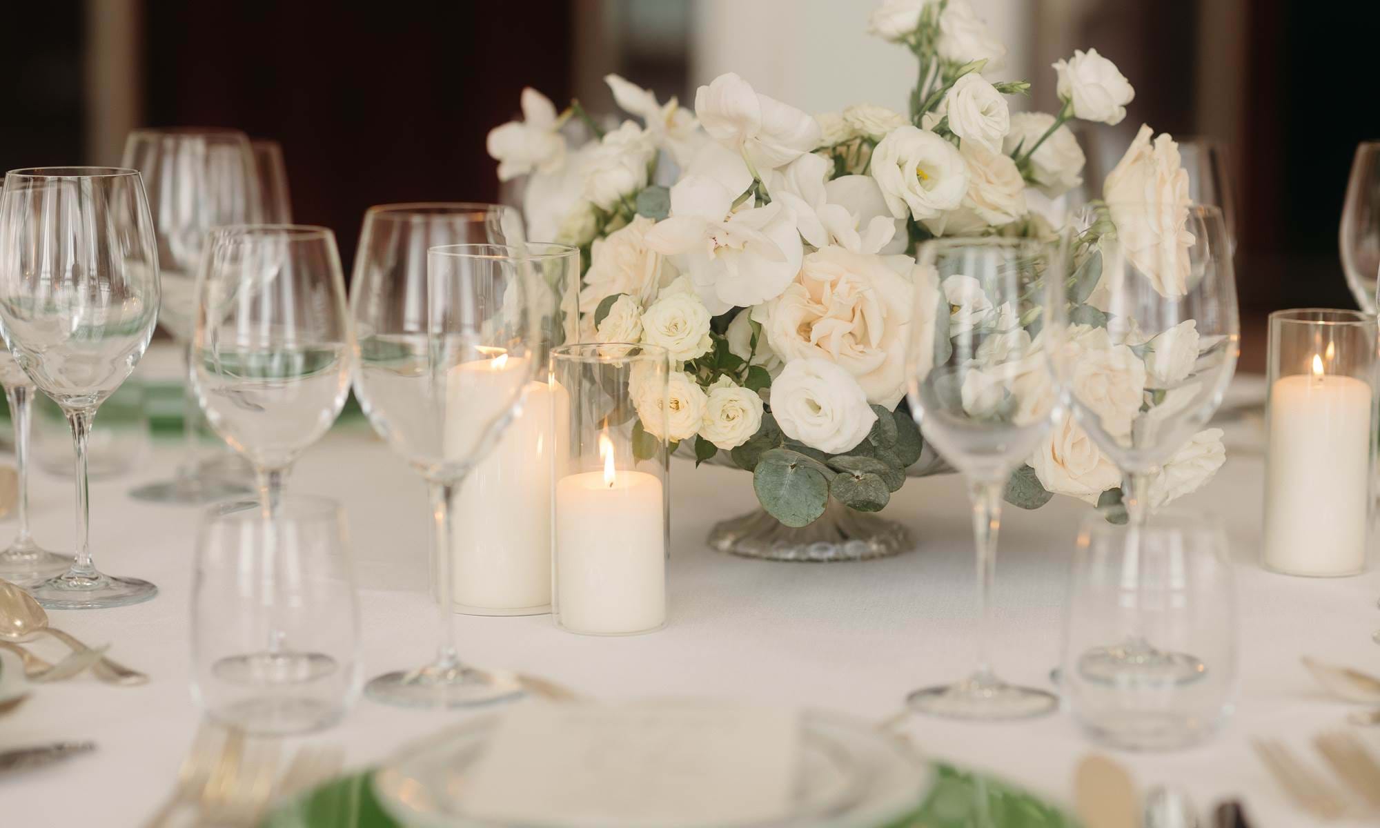 Elegant table setup for a romantic wedding in Venice Italy at Hotel Excelsior Venice Lido Resort, featuring soft candlelight and white roses