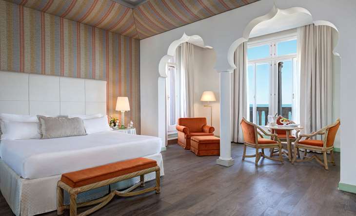 Venetian luxury suite with sea view and elegant seating, one of the finest suites in Venice, Italy.
