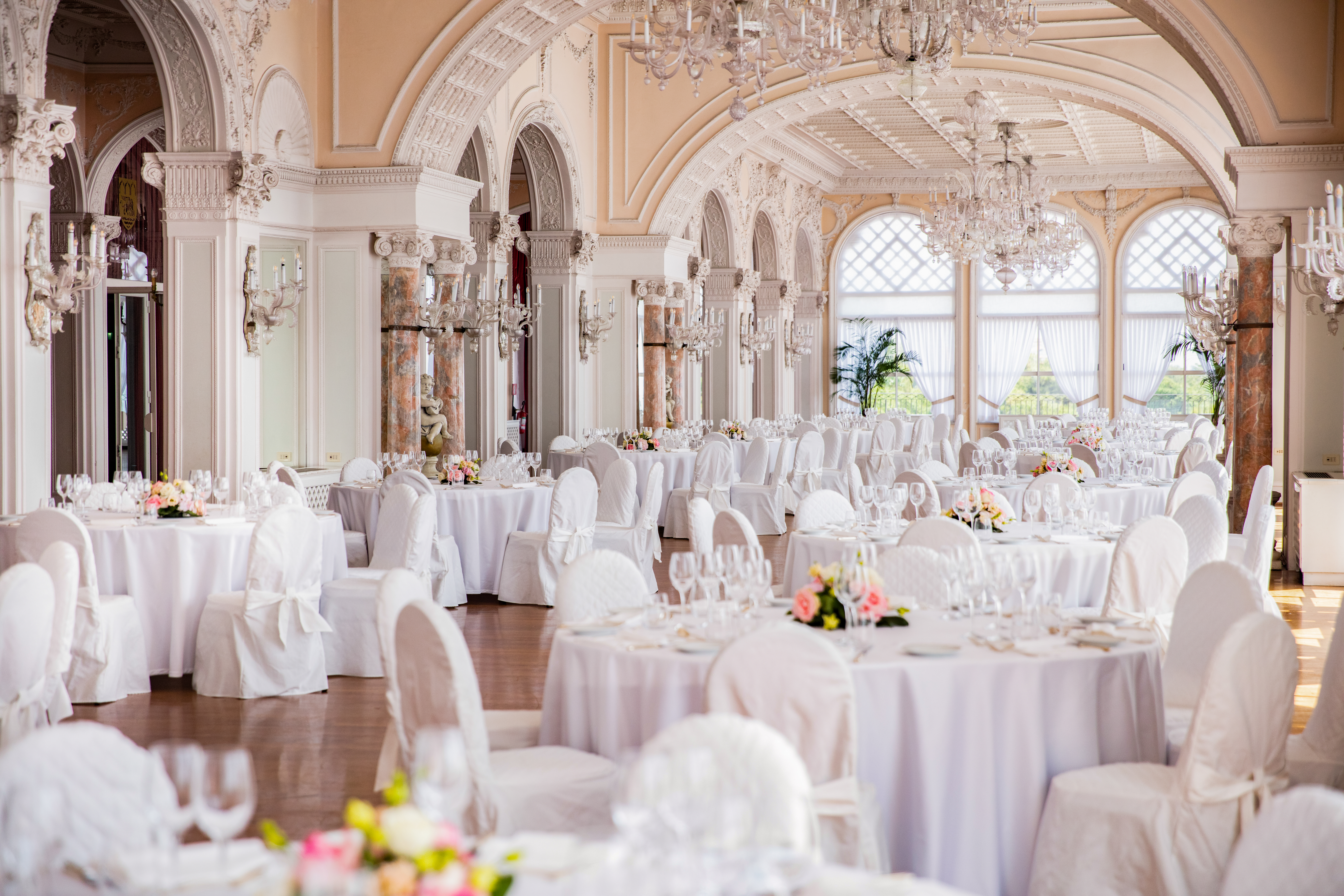 Luxurious ballroom wedding venue for a Venice wedding at Hotel Excelsior, with chandeliers, classical decor and tables set for a grand celebration