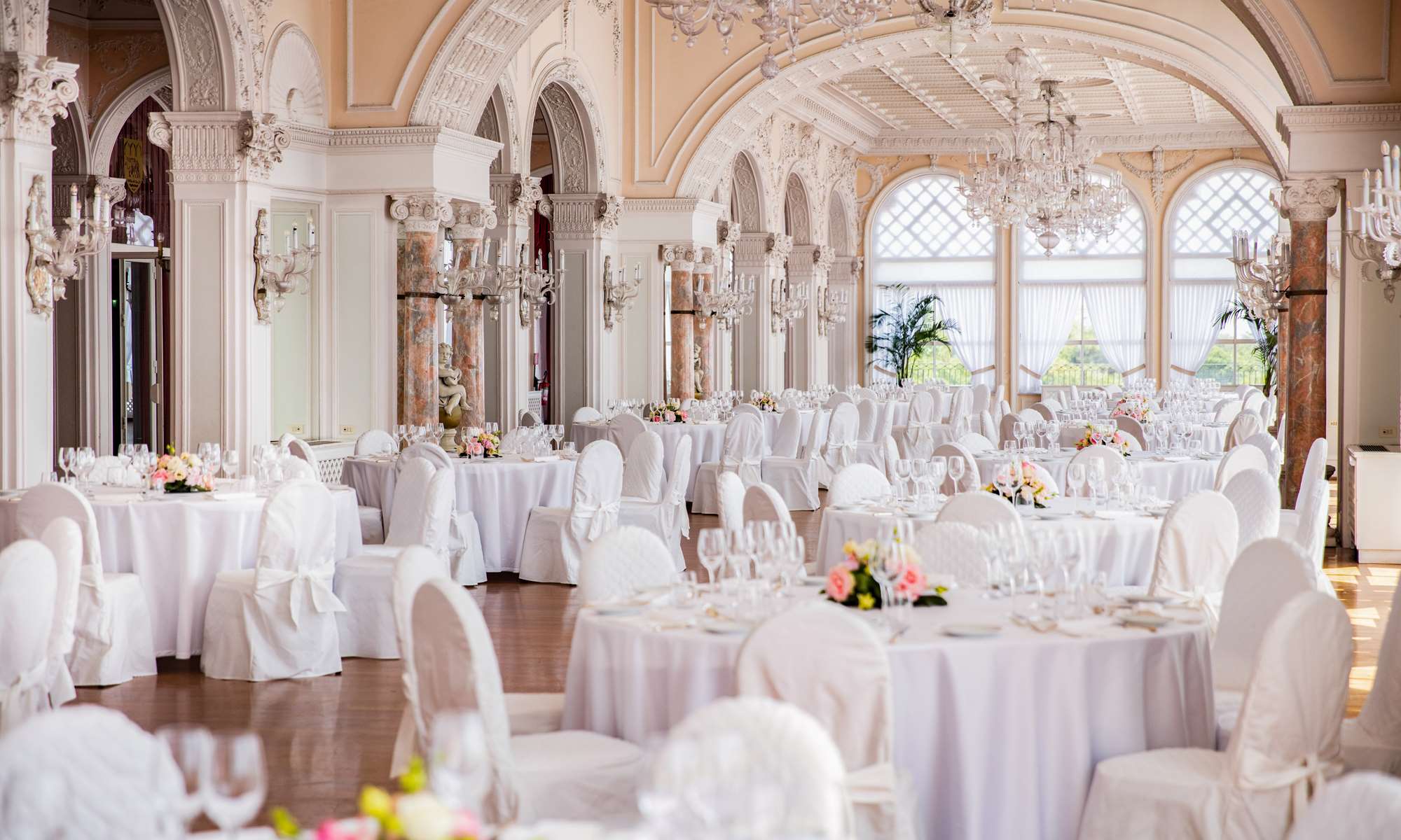 Luxurious ballroom wedding venue for a Venice wedding at Hotel Excelsior, with chandeliers, classical decor and tables set for a grand celebration